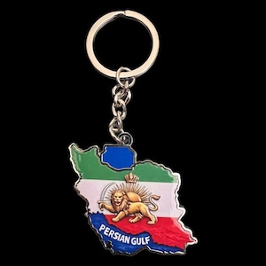 Puede incluir: Un llavero plateado con un mapa de Irán, que incorpora los colores de la bandera nacional y un emblema de león. El llavero tiene un anillo y una cadena plateados, con las palabras "PERSIAN GULF" impresas en la parte inferior.