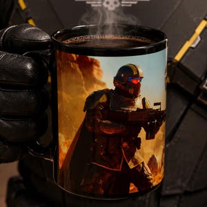 May include: A black ceramic mug filled with a steaming dark liquid. The exterior features a full-color graphic of a soldier in tactical armor with a helmet, red visor, and rifle, set against a desert landscape with orange and yellow flames.