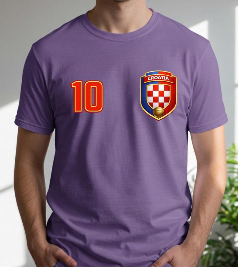 May include: A purple t-shirt featuring the number 10 in red with a gold outline on the left chest. On the right chest is a Croatian national team crest with a red and white checkered pattern, a gold soccer ball, and the word "CROATIA".