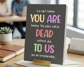 Puede incluir: Tarjeta de despedida con el texto "We can't believe YOU ARE leaving. This place will be DEAD without you. TO US you are irreplaceable..." en colores. Sobre un escritorio de madera con bolígrafo, cuaderno y planta.