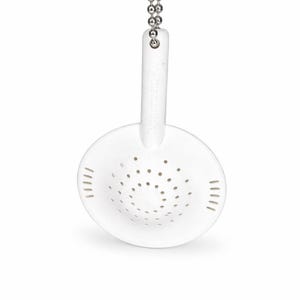 May include: A white, round tea infuser with a handle and a chain. The infuser has small holes for steeping tea leaves. The handle has the word "Tupperware" printed on it.