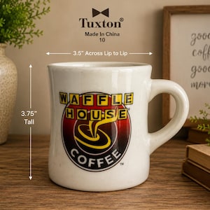 May include: A white ceramic Waffle House coffee mug. The mug is 3.75 inches tall and 3.5 inches across. The Waffle House logo is prominently displayed on the front, featuring a red, yellow, and black design.