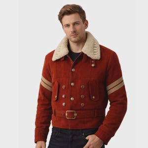 May include: A rust-colored suede jacket featuring a cream-colored faux shearling collar, double-breasted button closure, and a matching belt at the waist. The sleeves are accented with two horizontal tan stripes, and the jacket has two chest pockets.