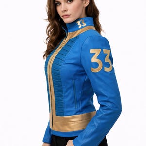 May include: A blue and gold jacket with the number "33" on the shoulder and collar. The jacket has a high collar, a gold zipper, and gold accents. The jacket is made of a smooth material.