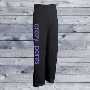 May include: Black sweatpants with the words "crazy pants" printed in purple on the left leg.