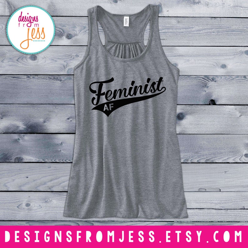 May include: Gray tank top with a black graphic that says "Feminist AF" in a vintage baseball font.
