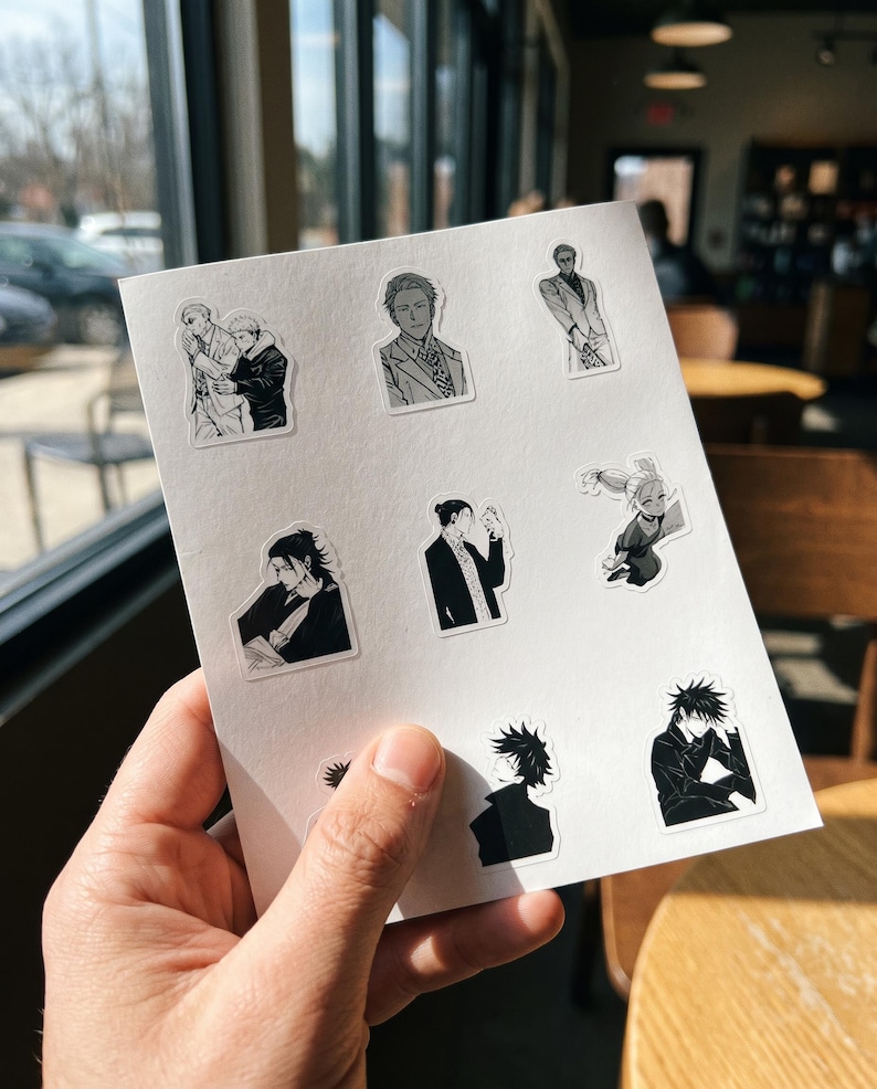 May include: A white sheet featuring eight individual black and white anime-style stickers. The designs depict various characters in different poses, including portraits, figures in suits, and dynamic stances, all rendered with detailed line work and shading.