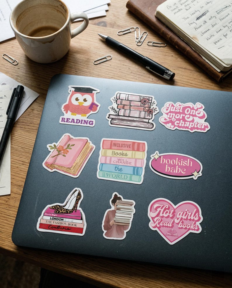 May include: A collection of colorful stickers with book-themed designs on a laptop. The stickers include an owl wearing a graduation cap, stacks of books, and phrases like "Just one more chapter" and "Hot girls Read books."