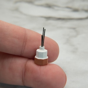 May include: A set of three ceramic mugs with a speckled, matte finish. The mugs are in shades of cream, light gray, and dark gray. Each mug has a simple, minimalist design, perfect for coffee or tea.