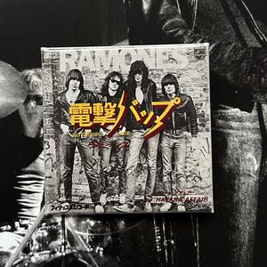 May include: A square Ramones album cover featuring the band members in front of a brick wall. The album cover has Japanese text and the words "HAVANA AFFAIR". The band members are wearing leather jackets and jeans.