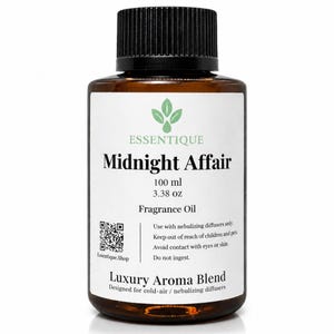 Könnte beinhalten: Eine braune Glasflasche mit "Midnight Affair" Duftöl und schwarzem Verschluss. Das Etikett enthält die Marke "Essentique", Produktdetails und Gebrauchsanweisungen. Die Flasche enthält 100 ml Öl.
