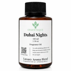 Könnte beinhalten: Eine braune Glasflasche "Dubai Nights" Duftöl mit schwarzem Deckel. Das Etikett enthält die Marke "Essentique", Produktdetails und Gebrauchsanweisungen. Die Flasche enthält 100 ml Öl.