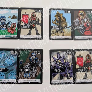 May include: Set of six illustrated trading cards with fantasy-themed artwork. Each card features a unique character or element, with text labels like "GOLD", "BUFF", "SPRITE", and "MECH". The cards have a black border and colorful illustrations.