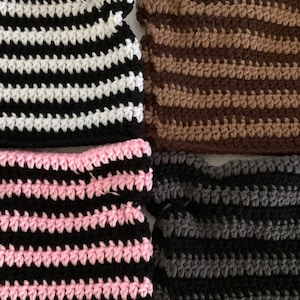 May include: Four crocheted striped fabric swatches in black and white, brown and tan, pink and black, and gray and black.