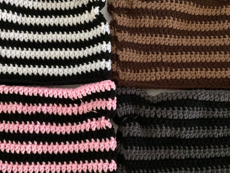 May include: Four crocheted striped fabric swatches in black and white, brown and tan, pink and black, and gray and black.