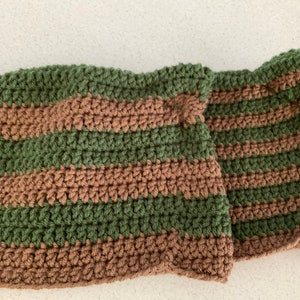 May include: A striped crocheted scarf in green and brown.