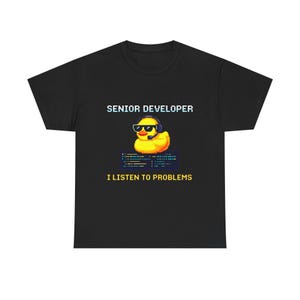 May include: Black t-shirt with the text "SENIOR DEVELOPER" above a pixelated yellow rubber duck wearing sunglasses and a headset. Below the duck, the text reads "I LISTEN TO PROBLEMS".
