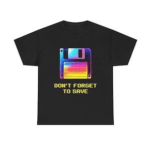 Könnte beinhalten: Schwarzes T-Shirt mit einem Retro-Grafikdesign einer Diskette in leuchtenden Farben. Der Text "DON'T FORGET TO SAVE" ist darunter in Gelb gedruckt. Ein nostalgisches Design für Computerfans.