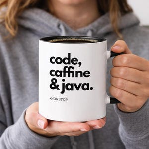 Pode incluir: Caneca de caf&eacute; branca com interior e al&ccedil;a pretos. A caneca apresenta o texto "code, caffeine & java." em preto. Abaixo do texto est&aacute; a palavra "#NONSTOP". A caneca est&aacute; cheia de um l&iacute;quido escuro.