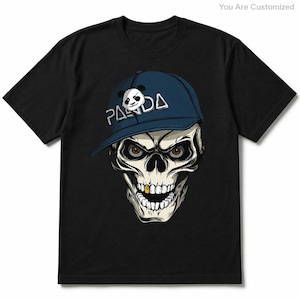 Può includere: Una t-shirt nera a maniche corte con la grafica di un teschio che indossa un berretto da baseball blu. Il berretto mostra un'icona di panda e il testo PANDA. Il teschio ha occhi marroni, un dente d'oro e la bocca aperta con denti bianchi.