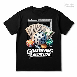 May include: A black t-shirt featuring a graphic print of a white die, stacks of one hundred dollar bills, red and green poker chips, and a gold coin. The text "GAMBLING ADDICTION" is printed in white below the graphic, along with coordinates and other small text.