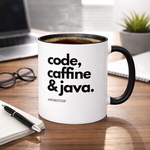 Pode incluir: Caneca de caf&eacute; branca com interior e al&ccedil;a pretos, cheia de caf&eacute; e vapor subindo. A caneca apresenta o texto "code, caffeine & java." abaixo do qual est&aacute; a palavra "#NONSTOP".