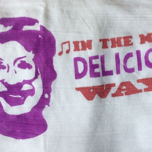 Puede incluir: Silueta morada de la cara de una mujer con el texto "in the most delicious way" en letras rosa y rojas con notas musicales a cada lado.