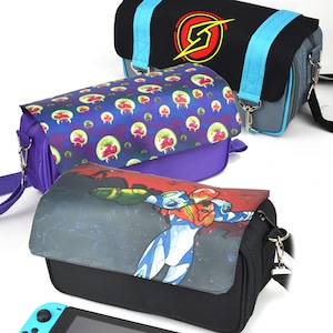 以下が含まれることがあります： ビデオゲームをテーマにしたデザインの、3つのカラフルなメッセンジャーバッグ。1つは、黄色と赤のエンブレムと青のアクセントが付いた黒色のバッグです。もう1つは、赤と緑の生き物のパターンが入った紫色のバッグです。3つ目のバッグには、スーツを着たキャラクターのグラフィックがあります。