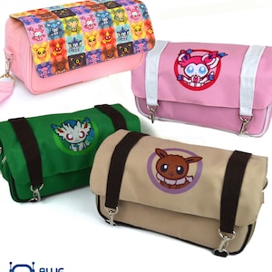 May include: Four colorful messenger bags with cartoon character designs. The bags are pink, green, and tan, with brown straps and silver clasps. One pink bag has a white strap and a character emblem. The top bag is pink with a colorful pattern.
