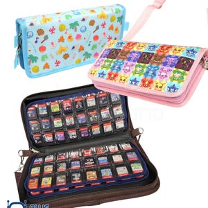 May include: Three game cartridge carrying cases. One is light blue with a pattern of colorful icons. Another is pink with a repeating cartoon character design. The third is brown and open, revealing numerous game cartridges.