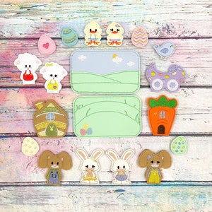 May include: A set of felt Easter-themed appliques featuring bunnies, chicks, lambs, a house, a carrot, a wagon, and eggs. The appliques are on a wooden background.