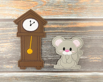 May include: A brown grandfather clock with a white face and black hands. A gray mouse with pink ears is sitting next to the clock.