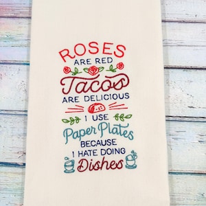 May include: Off-white kitchen towel with embroidered text in red and teal. The text reads "Roses are red, Tacos are delicious, I use paper plates because I hate doing dishes."