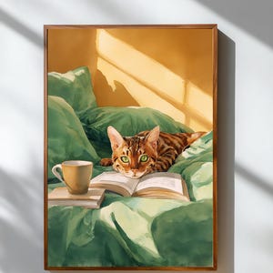 May include: A framed artwork depicts a Bengal cat with green eyes, lying on a bed with green bedding. A book and a coffee cup are on the bed. The artwork has a warm color palette with a wooden frame.