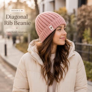 May include: A dusty pink beanie with a diagonal ribbed knit pattern and a folded cuff. A small white square tag with a brown heart icon is attached to the cuff. The text on the image reads: DESIGN 3, Diagonal Rib Beanie, Cozy, Stylish, Handmade.