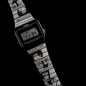 May include: Black Casio digital watch with a silver band featuring anime character illustrations and the text "SEE YOU SPACE COWBOY...". The watch face displays the time as 11:34.