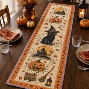 May include: A rectangular quilted table runner featuring a Halloween theme with illustrations of a black cat wearing a witch hat, jack-o'-lanterns, haunted houses, bats, and a broomstick. The fabric includes the text "TRICK OR TREAT" on a sign.