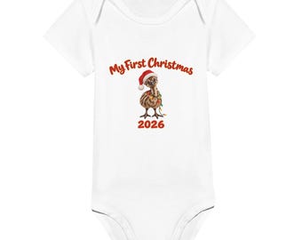 May include: A white short-sleeved baby bodysuit featuring a graphic of a brown emu chick wearing a red Santa hat and wrapped in colourful Christmas lights. The text above reads My First Christmas and the number 2026 is printed below.
