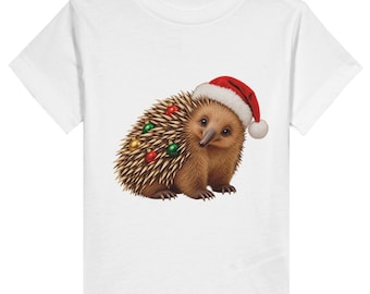 May include: A white short-sleeved t-shirt featuring a graphic of a brown echidna wearing a red and white Santa hat. The echidna has small red, green, and gold spherical ornaments nestled among its quills on its back.