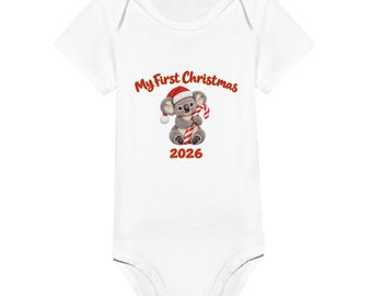 May include: A white short-sleeved baby bodysuit featuring a graphic of a koala wearing a red and white Santa hat and holding a red and white candy cane. The text above the koala reads My First Christmas and the number 2026 is printed below.