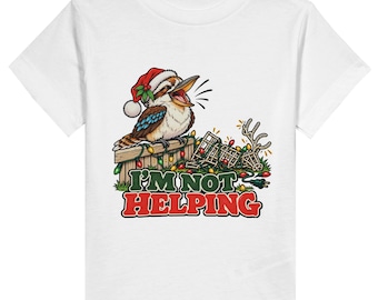 May include: A white t-shirt featuring a graphic of a kookaburra wearing a red Santa hat, perched on a wooden fence draped in colourful Christmas lights. Next to the bird is a tangled string of lights and the text I'M NOT HELPING in bold.