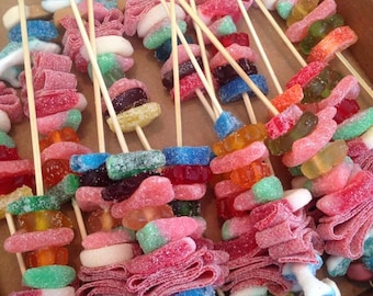 24 Candy Fruit Kabob Skewers rainbow colored with squishmallow axolotl marshmallow added on it.