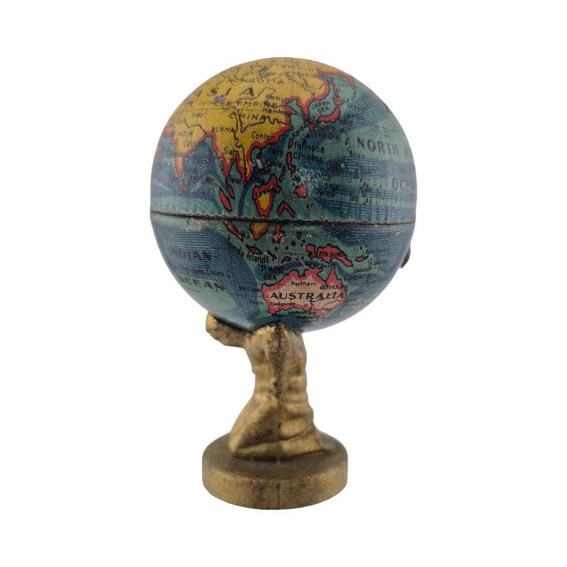 Op de afbeelding: Een vintage wereldbol met een gedetailleerde wereldkaart, met continenten in geel, rood en groen tegen een blauwe oceaan. De wereldbol wordt ondersteund door een goudkleurige voet, wat een klassiek decoratief stuk cre&euml;ert.
