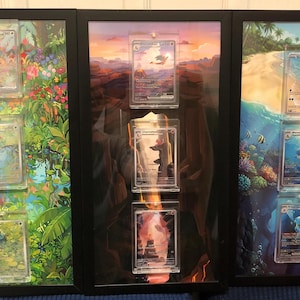 May include: Three framed artworks featuring Pokémon trading cards. The left frame has a jungle scene, the middle a sunset, and the right a beach scene. Each frame holds three cards in protective cases, creating a unique display.