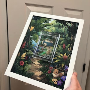 Könnte beinhalten: Ein gerahmtes Kunstwerk mit einer Pokemon-Karte von Relaxo in einer Schutzhülle, vor einer lebendigen Dschungelszene. Das Kunstwerk enthält Illustrationen von Pikachu und Evoli, mit üppigem Grün und bunten Blumen. Der Rahmen ist weiß.