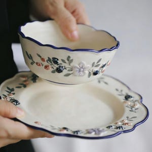Può includere: Un set di tre tazze in ceramica con finitura opaca e macchiettata. Le tazze sono nei toni del crema, grigio chiaro e grigio scuro. Ogni tazza ha un design semplice e minimalista e un manico arrotondato.