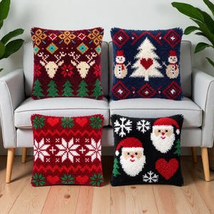Op de afbeelding: Vier vierkante sierkussens met getextureerde punch needle ontwerpen. Linksboven is kastanjebruin met rendieren en bomen. Rechtsboven is marineblauw met sneeuwpoppen en een boom. Linksonder is rood met sneeuwvlokken. Rechtsonder is zwart met kerstmannen.