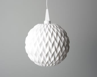 May include: A white, geometric pendant light fixture. The spherical shade features a repeating diamond pattern. The light hangs from a white cord and a conical ceiling mount. The overall design is modern and minimalist.