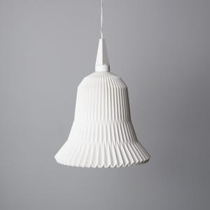 May include: A white, pleated pendant light fixture with a bell-shaped shade. The shade has a series of vertical folds, creating a textured surface. The light hangs from a white cord and has a geometric top.