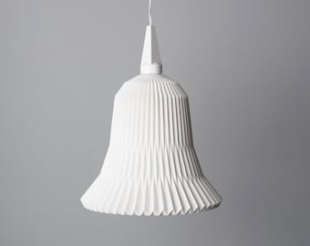 May include: A white, pleated pendant light fixture with a bell-shaped shade. The shade has a series of vertical folds, creating a textured surface. The light hangs from a white cord and has a geometric top.